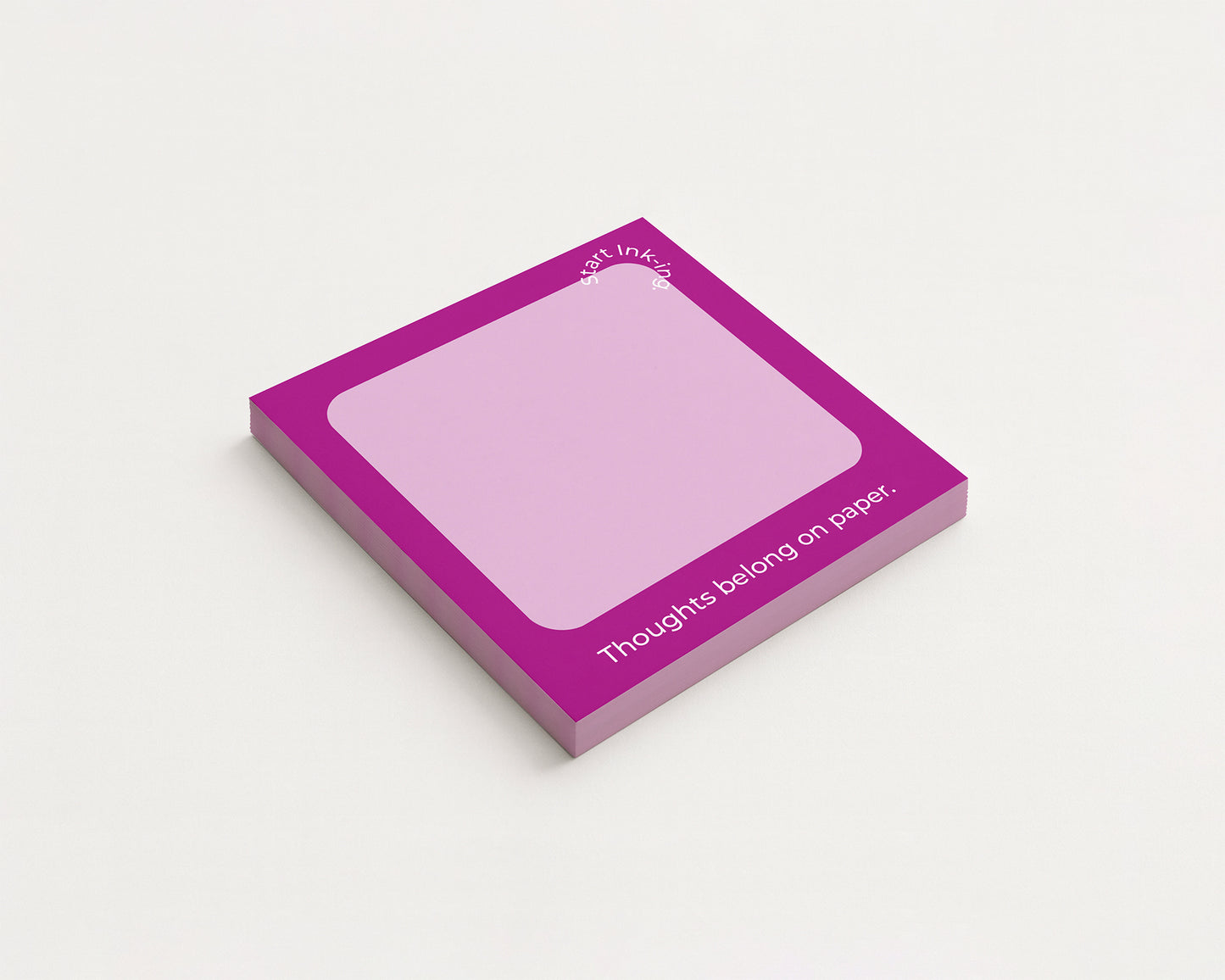 A square sticky note pad with a bright magenta border and a pale pink writing area, shown at an angle on a light gray background. White text on the pad reads 'thoughts belong on paper.